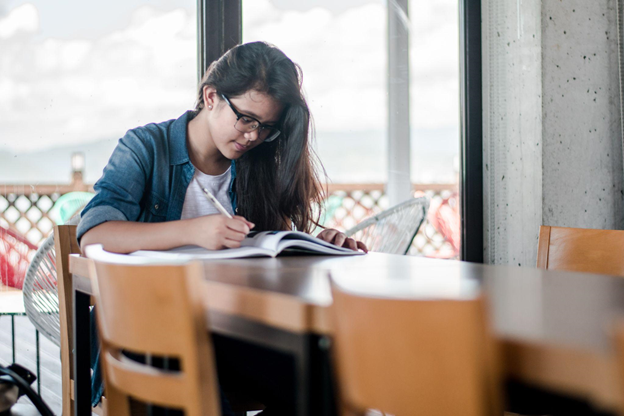 A student doing multiple languages exercises on her textbook